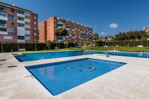 Una gran piscina con dos delfines en el agua. en APTO DUPLEX in from of the Sea, en Málaga