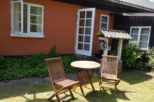 two chairs and a table in front of a house at Tabló in Frederiksværk