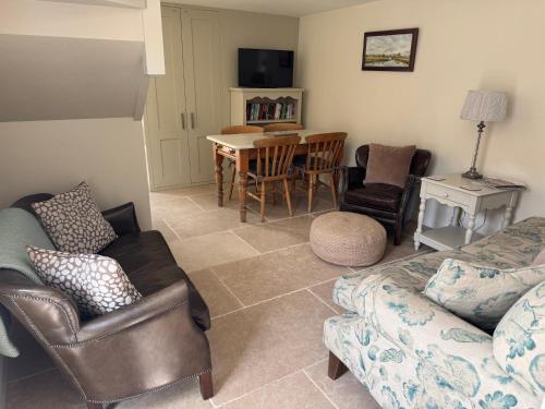 a living room with a couch and a table and chairs at Bank Top Barn Cosy Self Catering 4 Guests in Pickering