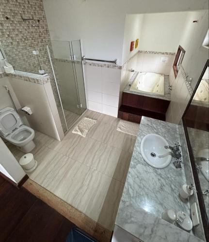 a bathroom with a toilet and a sink and a shower at Pousada Éden in Angra dos Reis