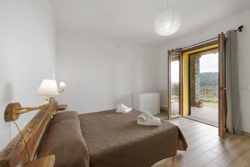 a bedroom with a bed and a sliding glass door at Agriturismo Le Macere in Sasseta