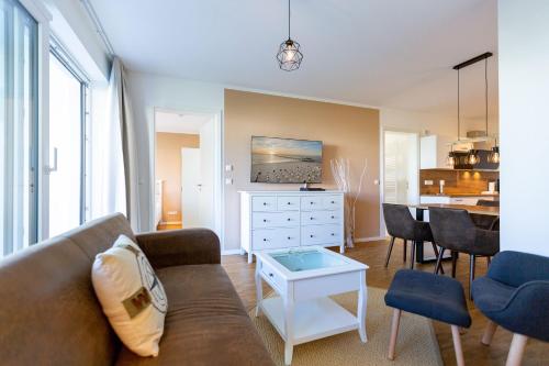 una sala de estar con un sofá y una mesa en Quartier 7 App 05, en Ahlbeck