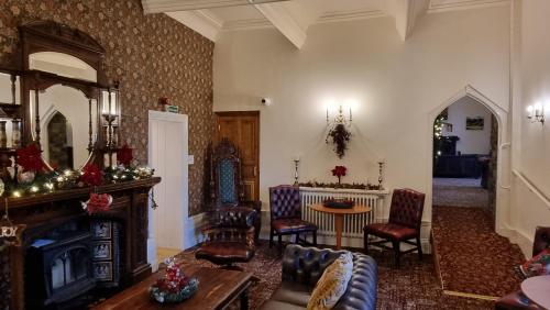 a living room with a couch and a fireplace at Craig-Y-Nos Castle in Abercraf