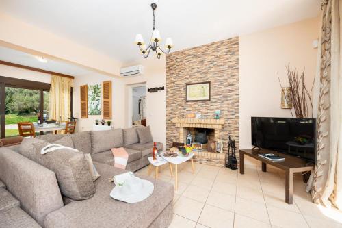 a living room with a couch and a fireplace at Villa Eufrosini in Svoronata