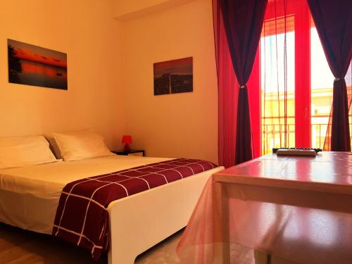 a bedroom with a bed and a window with red curtains at B&B MaryJosè in Trapani