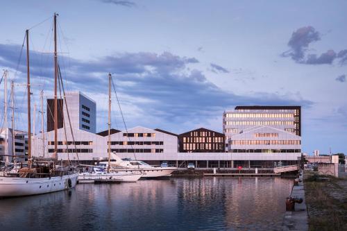 un groupe de bateaux amarrés dans un port avec des bâtiments dans l'établissement Montempô Apparthôtel Bordeaux Centre - Bassins à flot, à Bordeaux