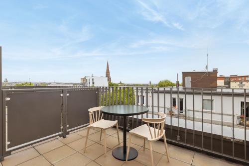 a patio with a table and chairs on a balcony at Limehome Bochum Kortumstr in Bochum