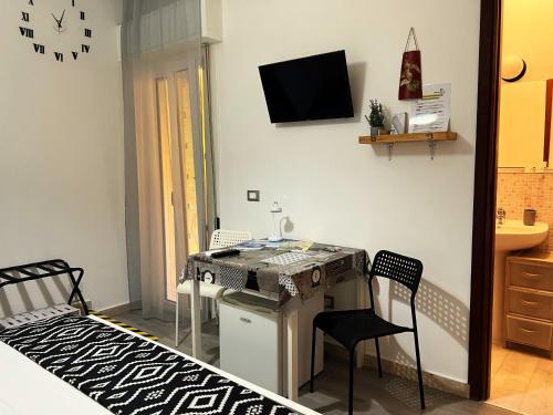a room with a desk with chairs and a tv on the wall at B&B MaryJosè in Trapani