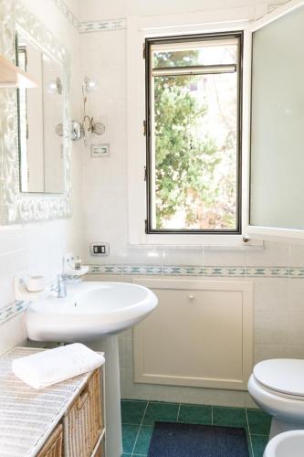 a white bathroom with a sink and a window at Marconi House - Appartamento in zona centrale 2-Bedr a Termini Imerese in Termini Imerese