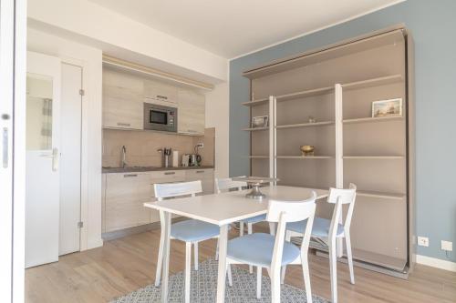 cocina con mesa blanca y sillas blancas en Classbnb - Well-located apartment near Monte Carlo, en Beausoleil