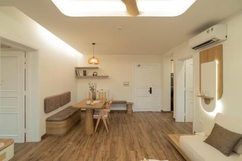 a living room with a table and a bench at The Fifth Home Thao Dien in Ho Chi Minh City