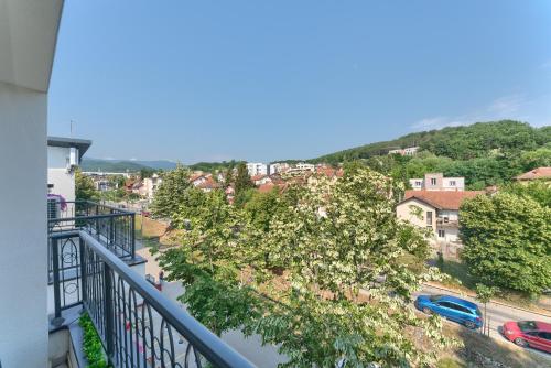 a balcony with a view of a town and a river at Duma Apartmani 2 Vrnjačka Banja in Vrnjačka Banja