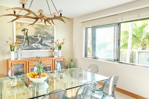 a dining room with a glass table and chairs at SG17 Villa Sable Front de Mer in Palmar