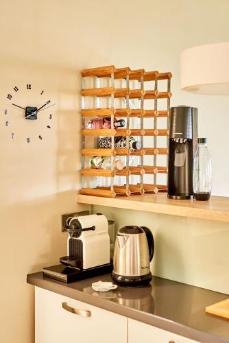 a kitchen counter with a coffee maker and a clock at SG17 Villa Sable Front de Mer in Palmar