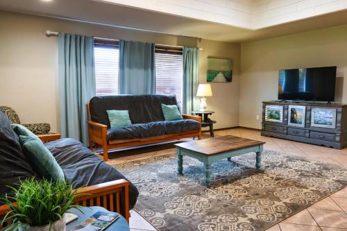 a living room with a couch and a tv at Lakefront Captains Quarters - 31 in Mead
