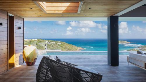 MarigotにあるPrestigious Villa with Inspired Architectureの海の景色を望む家のバルコニーが備わります。
