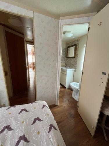a bedroom with a bed and a bathroom at Domek Czapla in Stare Sady