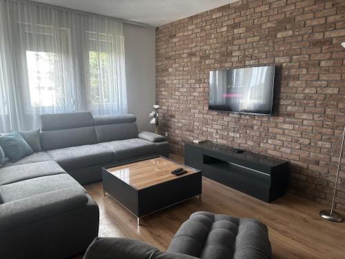 a living room with a couch and a brick wall at Crystal Lux in Veles