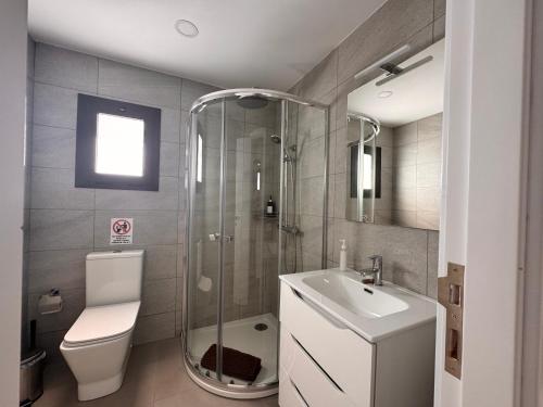 een badkamer met een douche, een toilet en een wastafel bij Yumbo Rainbow Homes A in Maspalomas