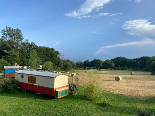 a small house sitting in the middle of a field at Roulottes des Combrailles in Saint-Pardoux