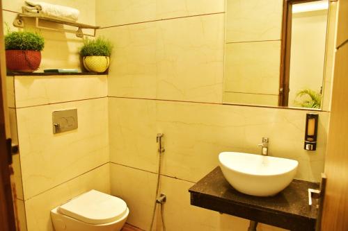 a bathroom with a sink and a toilet at Hotel 7-B in Chhatarpur