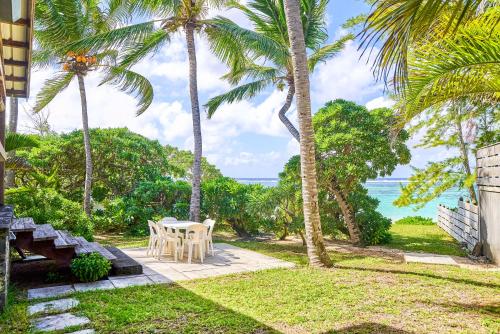 a patio with a table and chairs and palm trees at SG17 Villa Sable Front de Mer in Palmar