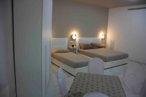 a bedroom with two beds and a table and chairs at Angela's dreams in Conversano