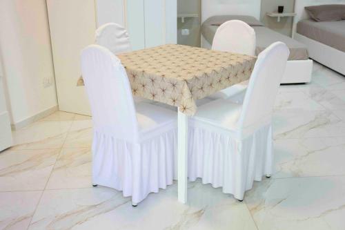 una mesa con 2 sillas blancas y una mesa con en Angela's dreams, en Conversano