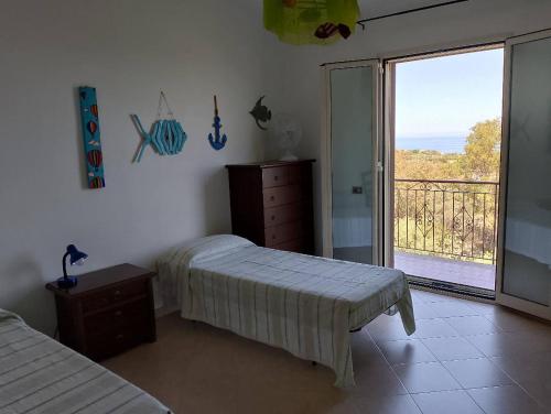a bedroom with two beds and a balcony with a view at Nuovo AliRu in Campofelice di Roccella