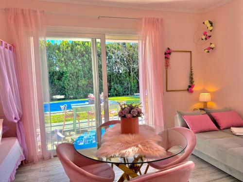 a living room with a glass table and pink chairs at Villetta Tinmar Barbie House Verona in Verona