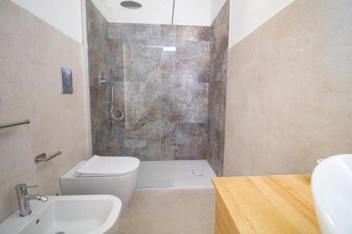 a bathroom with a shower and a toilet and a sink at Borgo Bianco affittacamere in Budoni