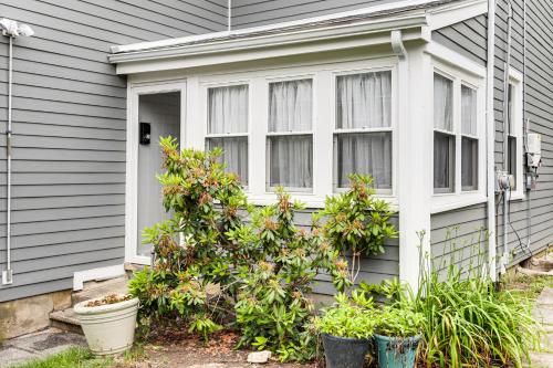 a house with windows and plants in front of it at 1 Mi to Needham Center Square Pet-Friendly Apt! 