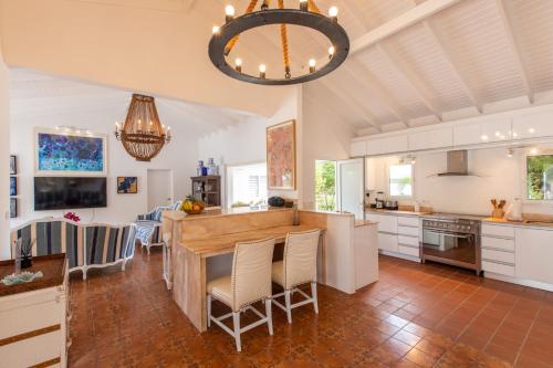 a kitchen with white cabinets and a large island at The Beach Bungalow Sisters in Baie Longue