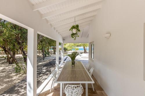 a wooden table on the porch of a house at The Beach Bungalow Sisters in Baie Longue