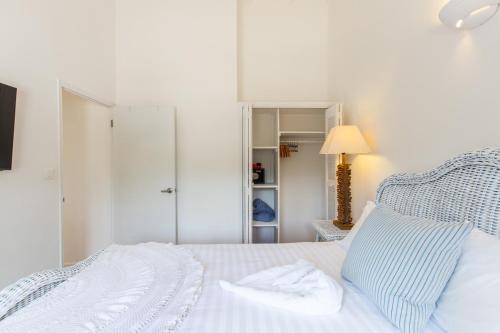 a bedroom with a bed with a blue and white bedspread at The Beach Bungalow Sisters in Baie Longue