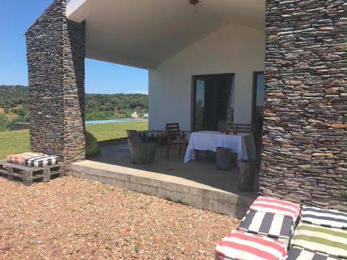 a patio with a table and a stone wall at Monte do Álamo da Serra in Redondo