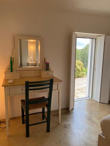 a desk with a mirror and a chair in a room at Monte do Álamo da Serra in Redondo