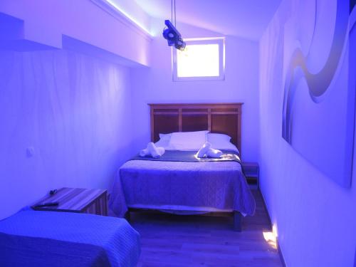 a bedroom with a bed with purple sheets and a window at Rooms&Restaurant 43 in Belgrade
