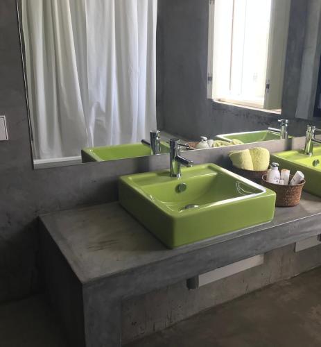 a bathroom with two green sinks and a mirror at Monte do Álamo da Serra in Redondo