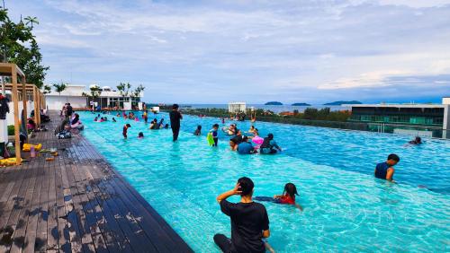 eine Gruppe von Menschen sitzt in einem Schwimmbecken in der Unterkunft 7Teenhomes - SA CozyStay in Kota Kinabalu