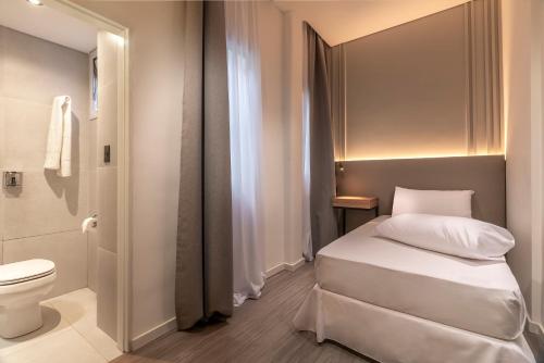 a small bathroom with a bed and a toilet at Up Central Córdoba in Buenos Aires
