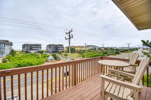a deck with two chairs and a table and a street at Walk to Beach and Restaurants Outer Banks Retreat in Kill Devil Hills