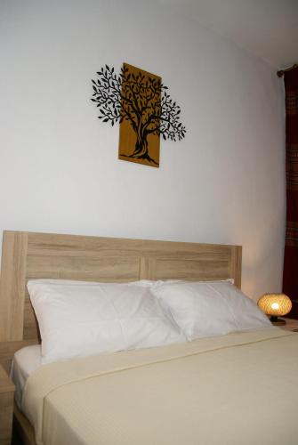 a bedroom with a bed with a tree on the wall at Socros Home, Mesta Chios in Mestá