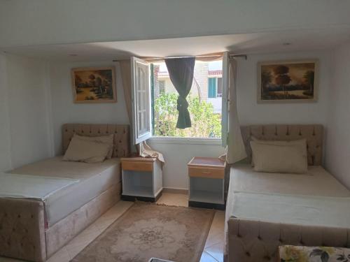 zwei Betten in einem Zimmer mit Fenster in der Unterkunft Chalets4A sea and pool view 2Bed rooms without lounge 114 at Green Beach in El-Alamein