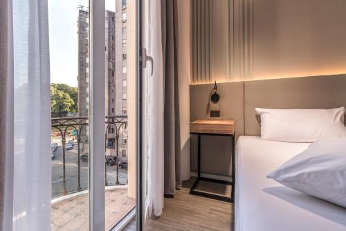 a bedroom with a bed and a balcony with a view at Up Central Córdoba in Buenos Aires