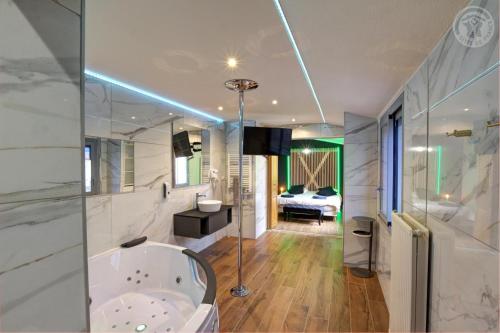 a large bathroom with a tub and a bedroom at Plenitude in Saint-Chamond