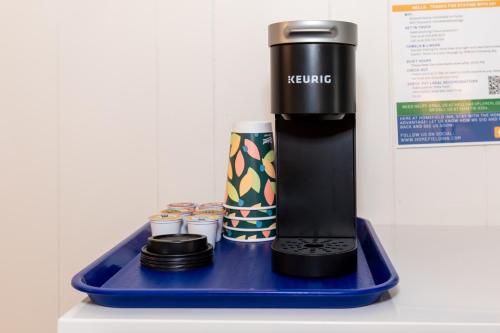a coffee maker on a blue tray with cups at HomeField Inn in Sandusky