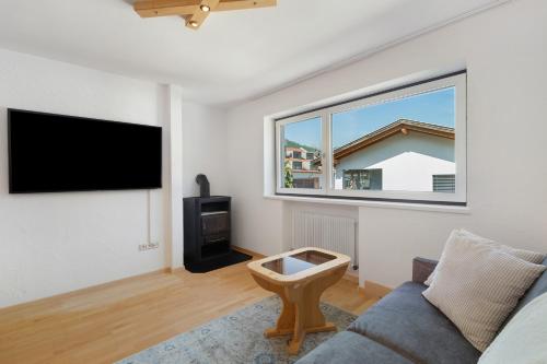 Una sala de estar con un sofá y una ventana. en Apt Hofer Monika, en Villabassa