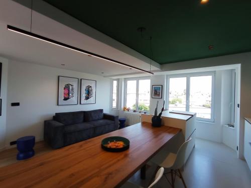 a living room with a table and a couch at Appartement lumineux 5 min de la plage in Dunkerque