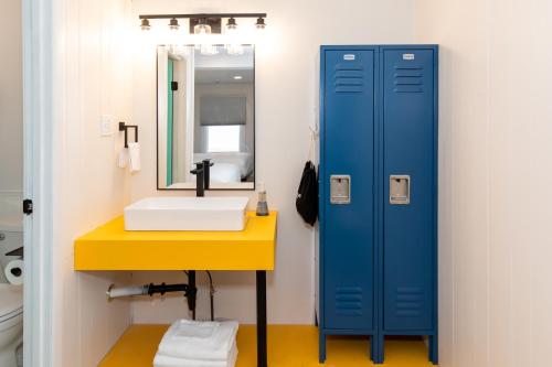 a bathroom with a blue locker next to a sink at HomeField Inn in Sandusky